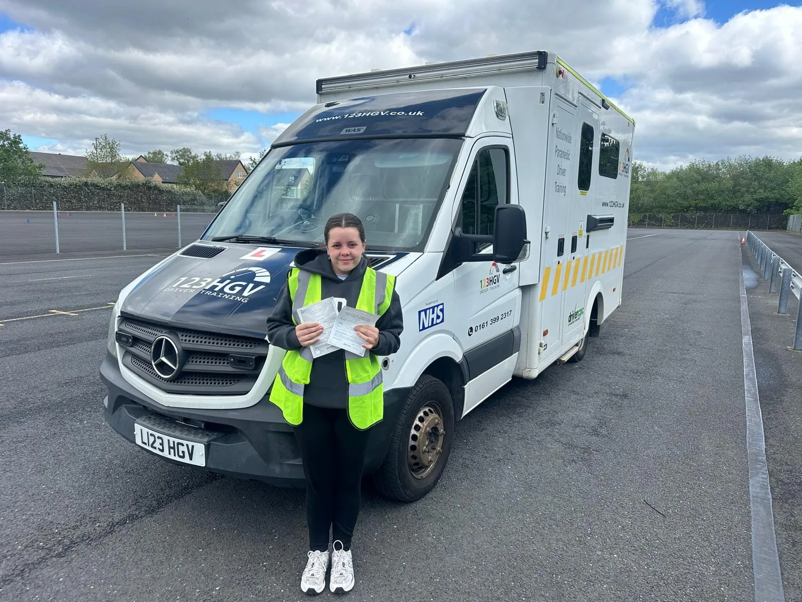 C1 learner pass image beside branded ambulance training vehicle